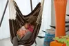 A mother and child relaxing in a hammock chair. Produktbild-Vorschau