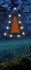 A decorative Christmas tree stake with lights in a garden at night. Produktbild-Vorschau