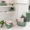 A collection of green storage baskets and pillows arranged in a room with white brick walls and white floor. Anteprima dell’immagine prodotto