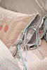 A close-up view of bedding with a strawberry and floral pattern. Produktbild-Vorschau
