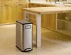 A stainless steel trash can with a pedal is placed next to a kitchen island in a modern kitchen. Náhľad obrázku produktu