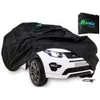 A black car cover is draped over a white toy car. A small black pouch with a logo is in the background. Produktbild-Vorschau