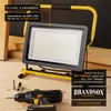 A work light and a drill are on a wooden surface, with text overlays highlighting product features. Anteprima dell’immagine prodotto