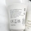 Close-up of the label on a Philips Hue smart light bulb, showing technical specifications and certifications. Náhled obrázku produktu