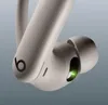 Close-up of a beige Beats Powerbeats Pro earbud with a green indicator light. Náhled obrázku produktu