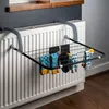 A drying rack for socks is attached to a radiator, with several pairs of socks hanging on it. Produktbild-Vorschau