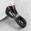 A black and red USB/USB-C charging cable is coiled on a textured gray surface, with a white curved object in the background. Náhľad obrázku produktu