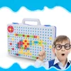 A child wearing glasses is looking at a toy construction set with colorful blocks and screws. Produktbild-Vorschau