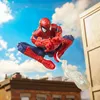 Spider-Man figure in mid-air, with buildings and sky in the background. Podgląd zdjęcia produktu