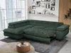 A green sectional sofa with a pull-out bed feature is shown in a modern living room setting with large windows and decorative items on a shelf. Produktbild-Vorschau