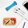 A flat lay of a lunchbox with a sandwich and tomatoes, cutlery set, a phone, and a keyboard. Produktbild-Vorschau