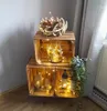 A rustic display of wooden crates decorated with fairy lights and natural elements. Náhled obrázku produktu