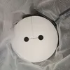 A white circular object with two black circles representing eyes, resembling a character's face, is nestled within a grey, textured material. Produktbild-Vorschau