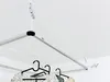 A ceiling-mounted clothes drying rack with clothes hanging on it. Voir les images du produit