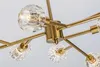 A close-up view of a gold chandelier with multiple crystal glass shades. Podgląd zdjęcia produktu