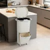 A beige multi-compartment kitchen trash can with a lid and a pull-out lower bin is shown in a modern kitchen setting. Anteprima dell’immagine prodotto