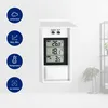 A digital thermometer with a white casing, mounted on a white wall. Icons and text are displayed to the left of the thermometer. Produktbild-Vorschau
