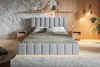 A modern bedroom with a grey upholstered bed as the focal point, flanked by wooden nightstands and decorated with subtle wall art and lighting. Náhled obrázku produktu