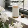 An aroma diffuser is placed on a windowsill next to white lilies and essential oil bottles. Produktbild-Vorschau