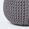 A close-up view of a grey knitted pouf. Náhled obrázku produktu