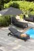 A poolside patio with lounge chairs, an umbrella, and a sofa. Produktbild-Vorschau