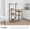 A kitchen shelf unit is shown in a kitchen setting next to a round table. Náhled obrázku produktu