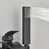 A close-up of a black bathtub faucet and showerhead with water spraying from the showerhead. Náhled obrázku produktu