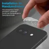 A hand is shown applying a clear camera lens protector to the back of a black smartphone. Produktbild-Vorschau