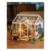 A miniature greenhouse model with gardening tools and plants. Anteprima dell’immagine prodotto