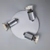 A ceiling spotlight with three adjustable heads is shown against a plain gray background. Voir les images du produit