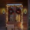 A decorated doorway for Christmas with wreaths, garland, and two ceramic Christmas tree night lights. Náhľad obrázku produktu