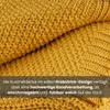 Close-up of a textured yellow knitted blanket with a text overlay describing its features. Náhľad obrázku produktu