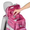 A hand is shown adjusting a mechanism on a pink backpack, which is placed on a mannequin. Produktbild-Vorschau
