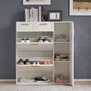 A white shoe cabinet with golden handles, filled with various shoes, is placed against a gray wall. Anteprima dell’immagine prodotto