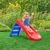 A young child is playing on a red and blue slide in a garden. Anteprima dell’immagine prodotto
