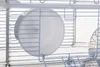 A close-up view of a hamster cage interior, showing a white exercise wheel and part of a clear plastic accessory. Anteprima dell’immagine prodotto