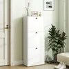 A white shoe cabinet with three flip-down doors stands in a hallway next to a door and a large potted plant. Produktbild-Vorschau