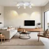 A modern living room with a white sofa, coffee table, TV, and a wooden media console, illuminated by a white ceiling light. Produktbild-Vorschau