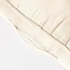 A close-up view of a cream-colored cushion, showing its textured fabric and stitching. Náhled obrázku produktu