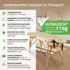 A beige massage table with wooden legs is shown in a room with a blurred background. Text overlays highlight product features. Produktbild-Vorschau