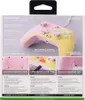 The image shows the packaging of a pink and yellow Xbox controller, with various features highlighted by text and smaller inset images. Náhľad obrázku produktu