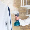 A hand holding a garment steamer to a white shirt. Produktbild-Vorschau