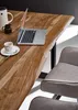 A laptop, coffee cup, and pitcher are on a wooden table next to a chair. Produktbild-Vorschau
