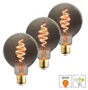 Three smoke-colored globe LED light bulbs with spiral filaments are arranged diagonally on a white background. Produktbild-Vorschau
