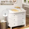 A white dresser with a changing pad on top, in a nursery or child's room. Produktbild-Vorschau