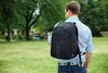 A man wearing a backpack walks in a park. Náhľad obrázku produktu