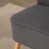 A close-up view of a dark gray upholstered sofa with light wood legs, resting on a light beige rug. Produktbild-Vorschau