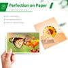 Marketing image showing a hand holding a photograph of a butterfly and a separate photograph of a sunflower, with text describing product features. Produktbild-Vorschau