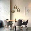A dining table with chairs and pendant lights in a modern dining room. Produktbild-Vorschau