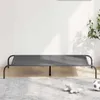 A grey elevated dog bed is shown in a room with a white wall and a light grey rug. Anteprima dell’immagine prodotto